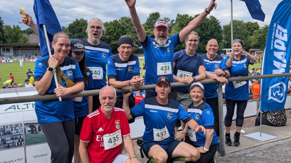 Laufen FT Gern Gruppe von Frauen und Männern mit blauen Lauf-Trikots lacht in die Kamera